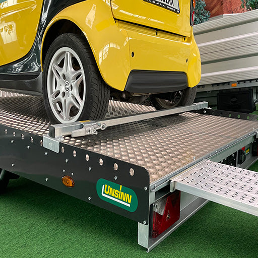 UNSINN Fahrzeugtransporter mit PKW beladen und Sicherungsschiene verzurrt